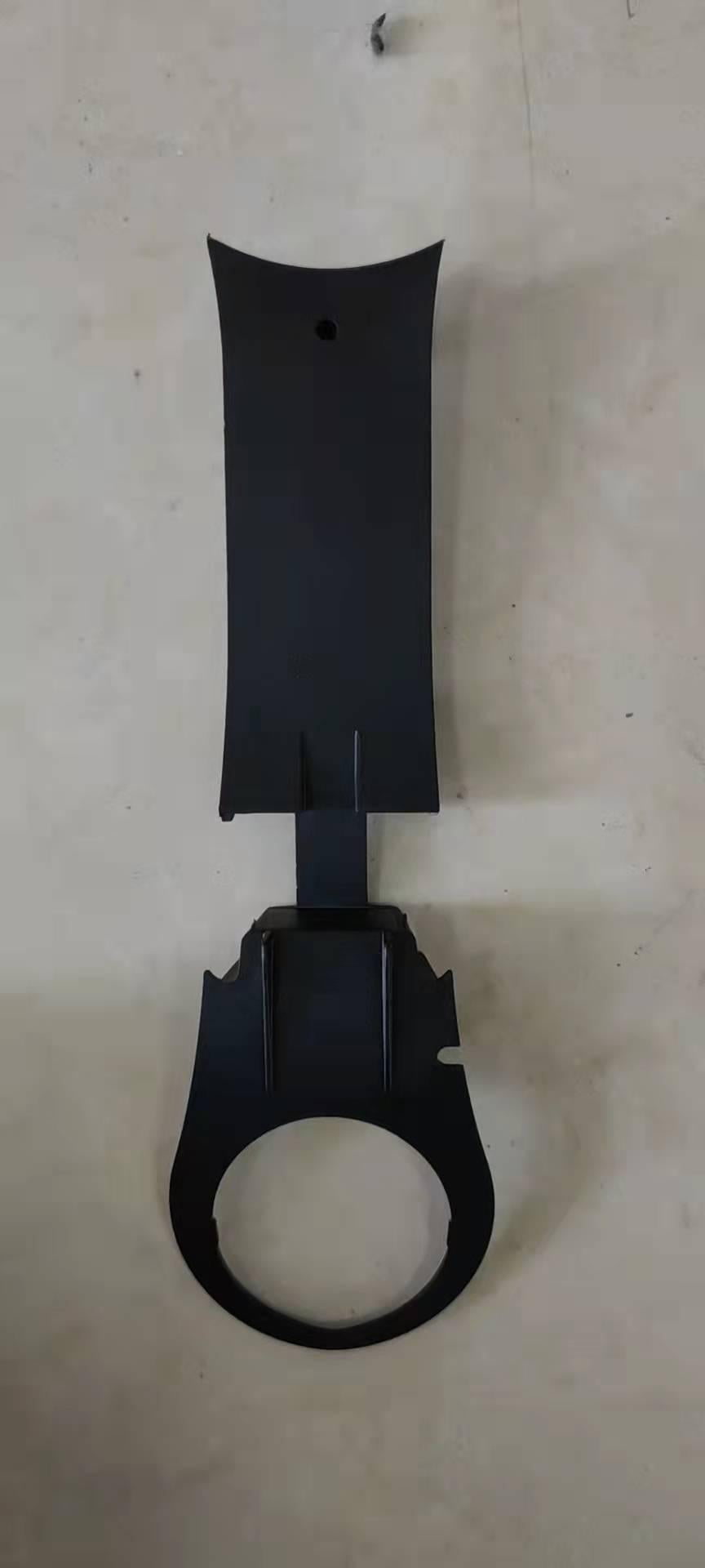 Cache garde-boue noir de bras oscillant avant gauche posé à plat sur fond clair