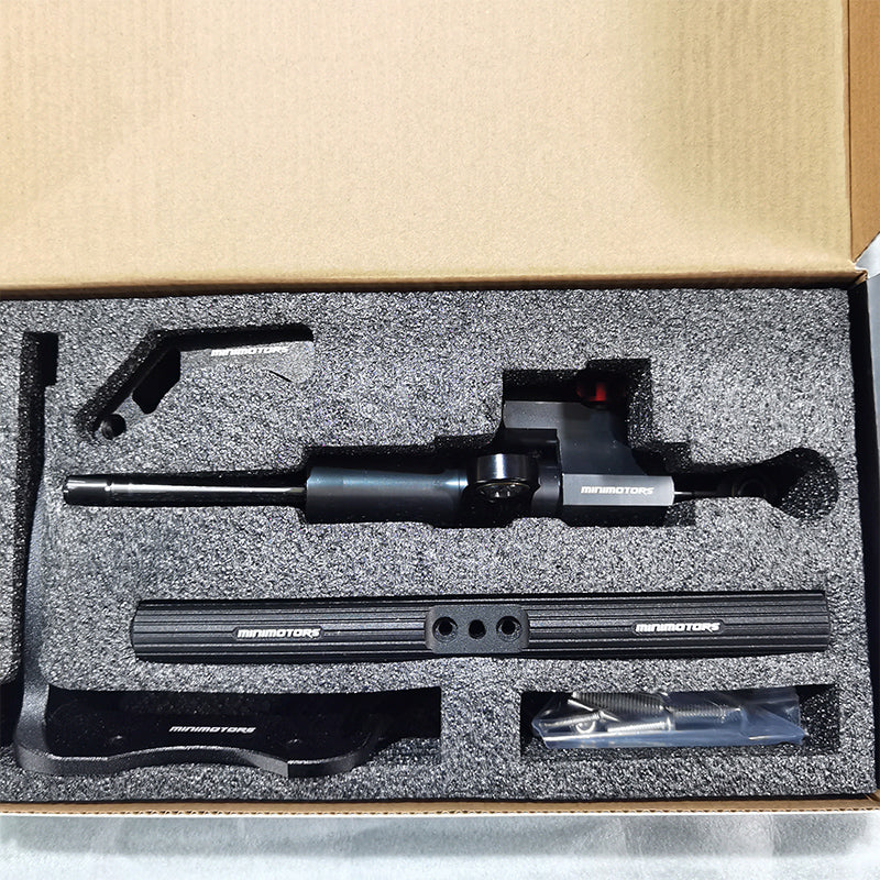Kit d'amortisseur de direction noir Minimotors avec ses fixations et sa visserie rangés dans une mousse de protection