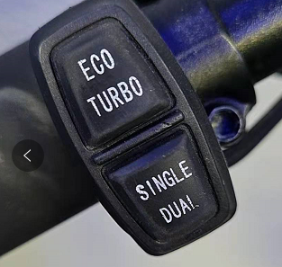 Commodo noir avec boutons Eco Turbo et Single Dual fixé sur un guidon