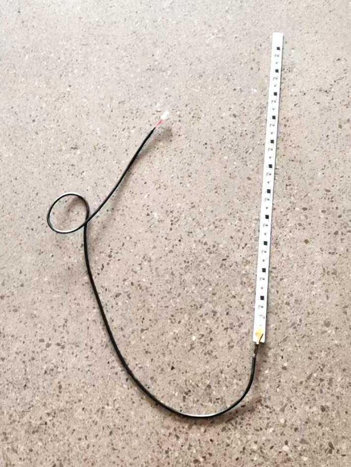 Bande LED pour potence de trottinette électrique Dualtron Thunder 2 avec son câble de connexion sur un sol moucheté