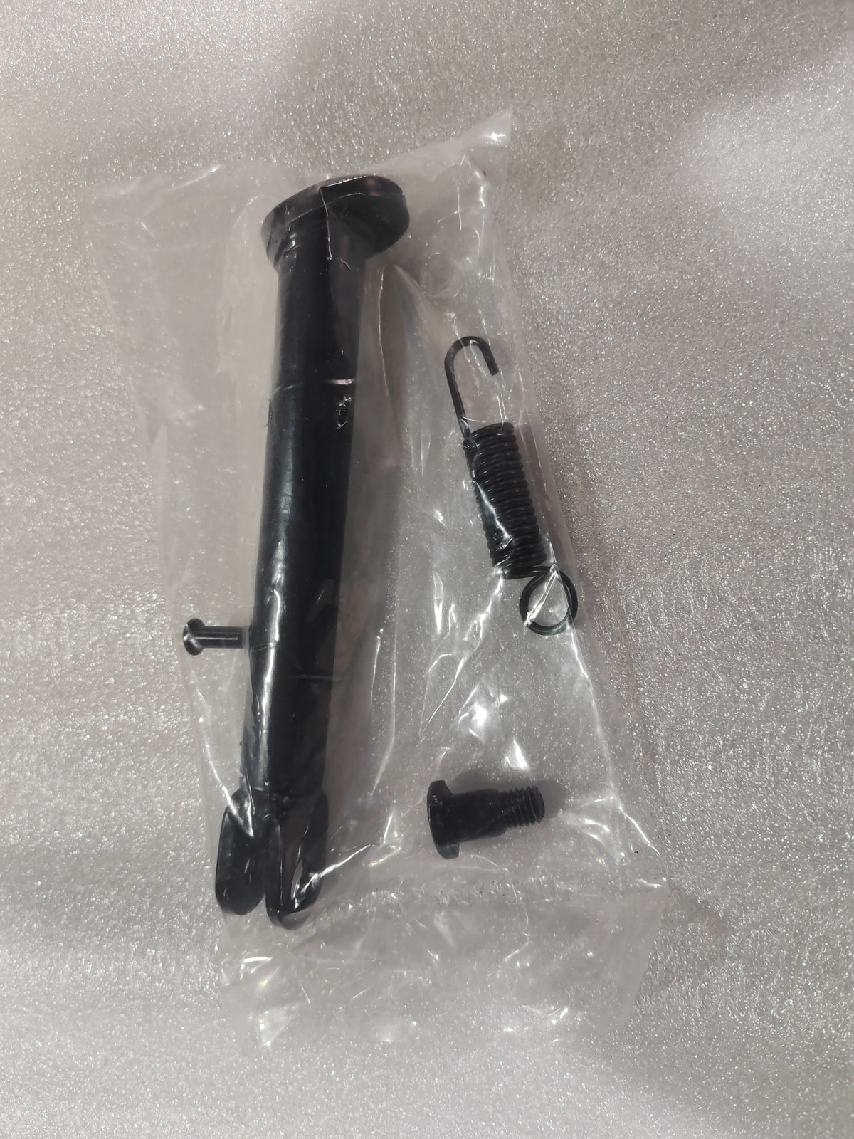 Béquille noire pour trottinette Rovoron R5 avec son ressort et sa vis de fixation sous sachet plastique