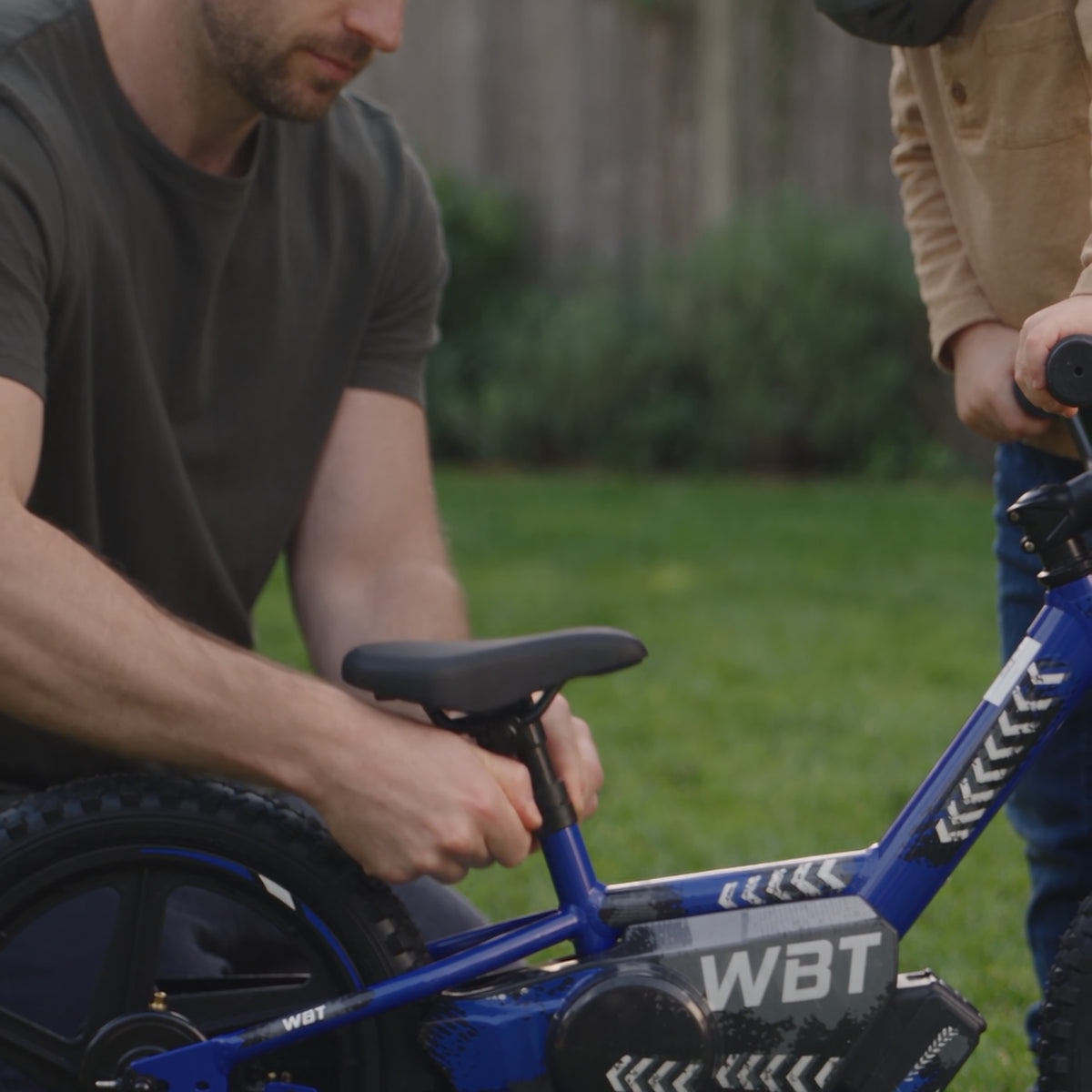 Un parent règle la selle de la WBT Kick devant son enfant