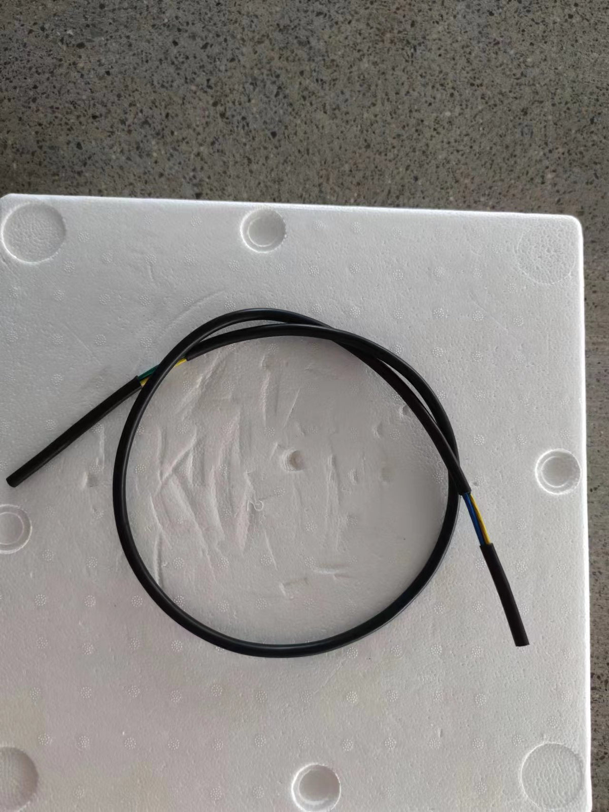 Câble moteur arrière noir de 1,05m enroulé sur un socle en polystyrène blanc