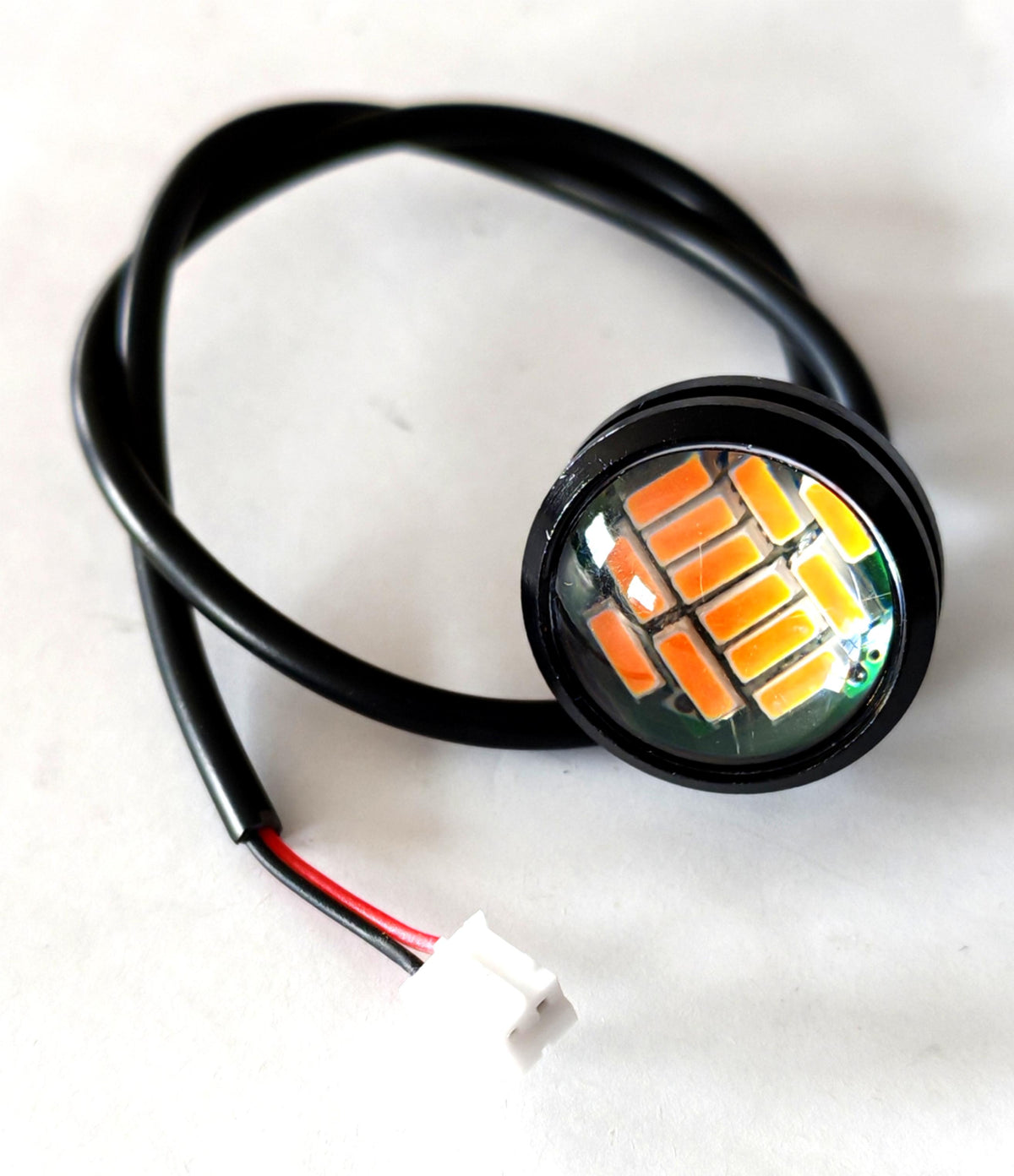 Feu d'avertissement LED rond avant relié à son câble et connecteur blanc.