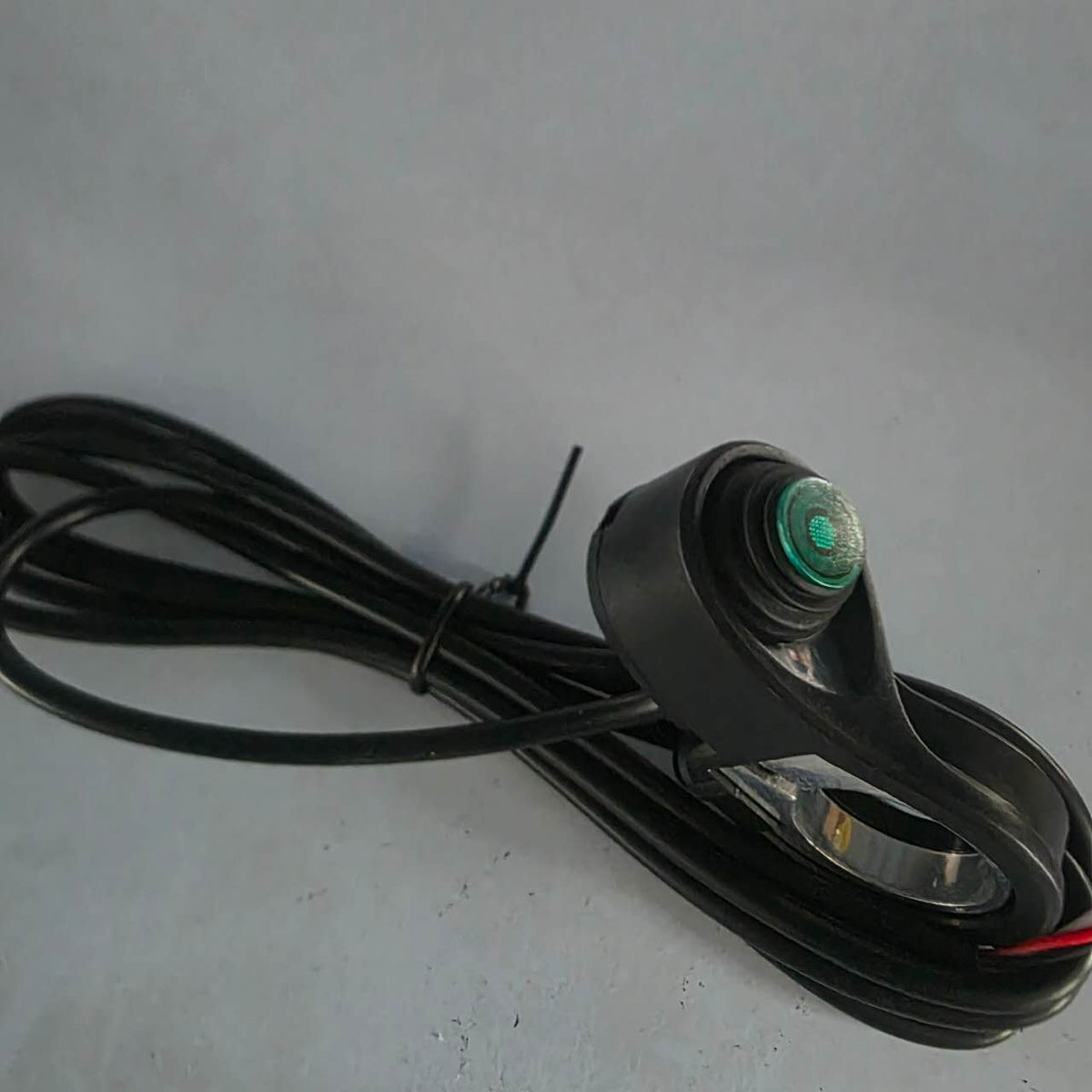 Bouton interrupteur turbo vert avec son câble noir enroulé