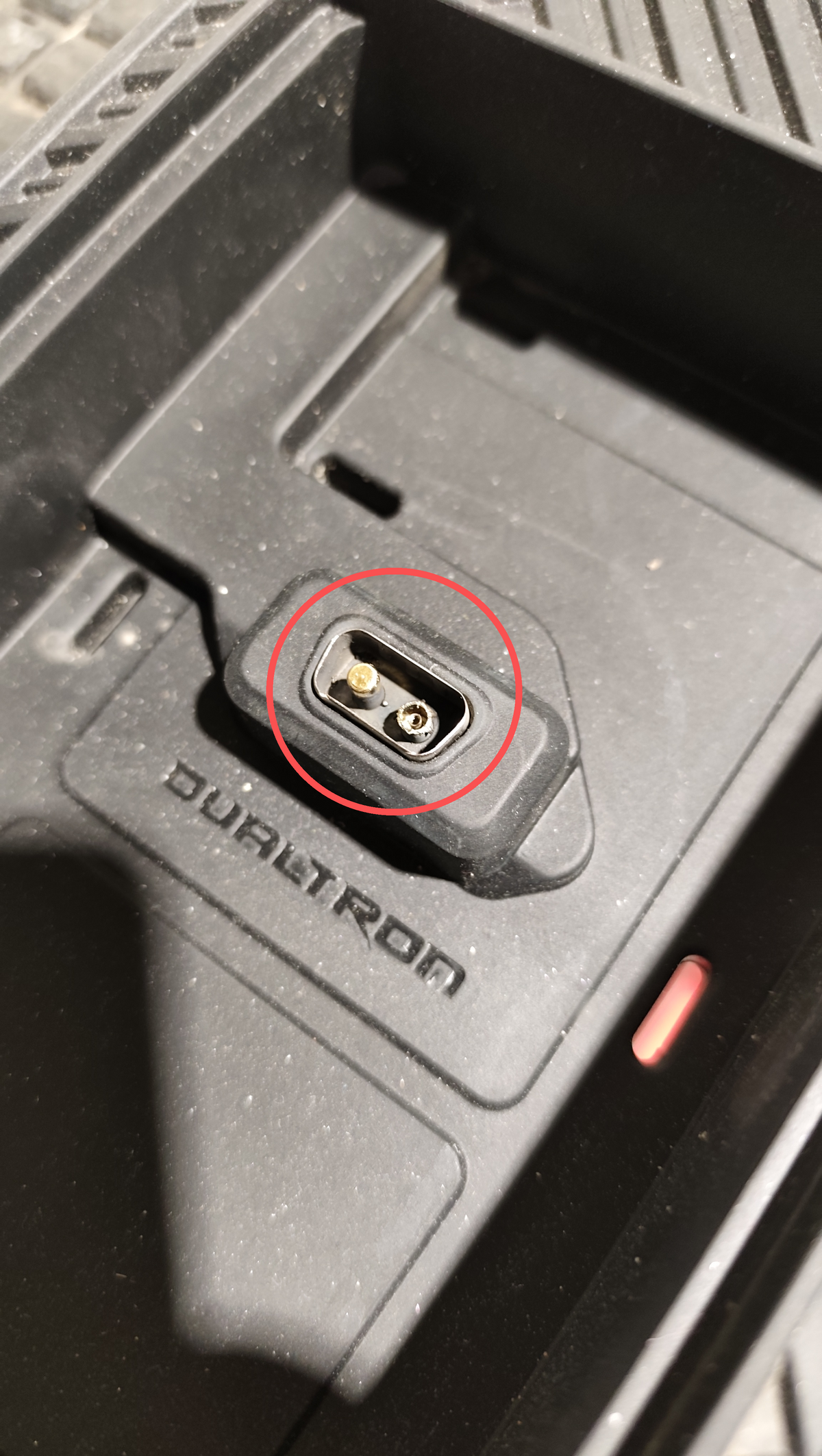Connecteur de décharge encastré dans le châssis d'une trottinette électrique Dualtron Sonic N entouré d'un cercle rouge