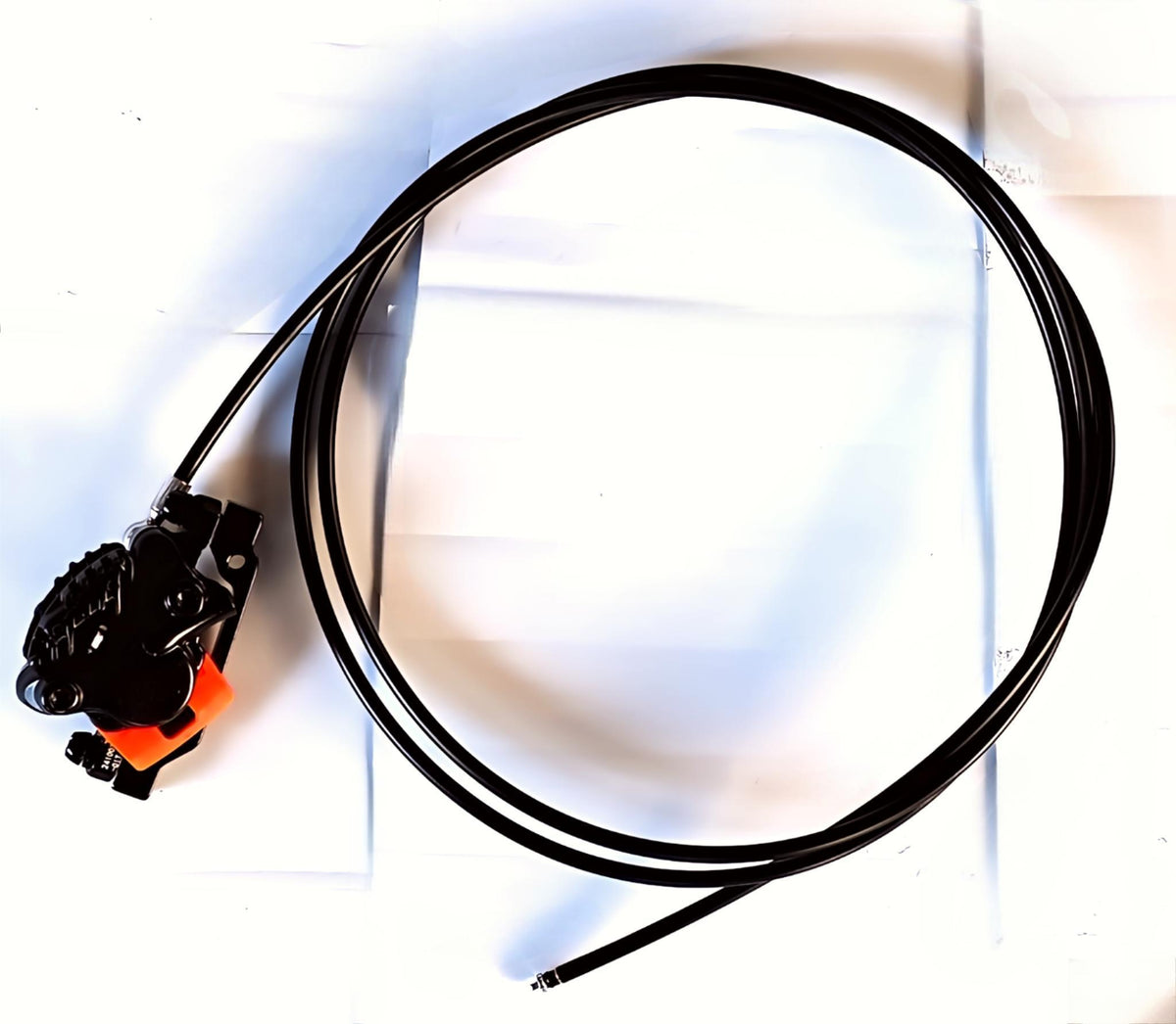 Étrier de frein hydraulique arrière noir avec sa durite enroulée sur fond blanc