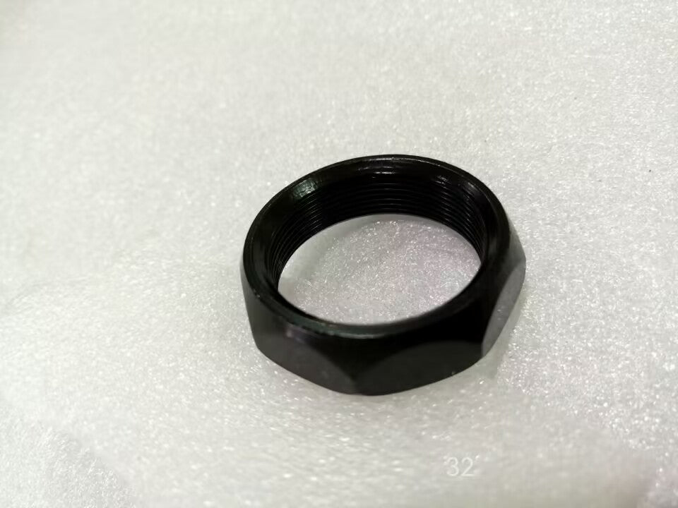Écrou de jeu de direction inférieur noir de trottinette électrique Dualtron posé sur une surface blanche