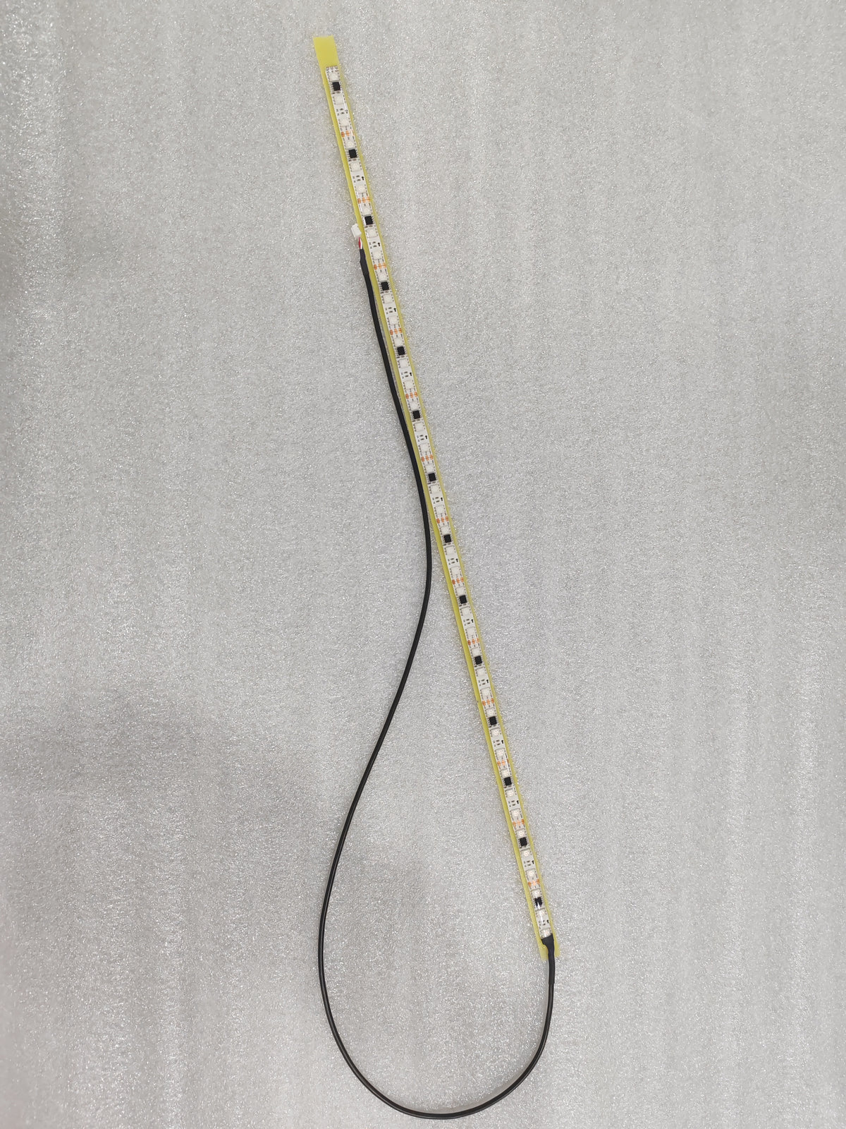 Barre LED gauche pour colonne de direction avec son câble de connexion noir posée à plat