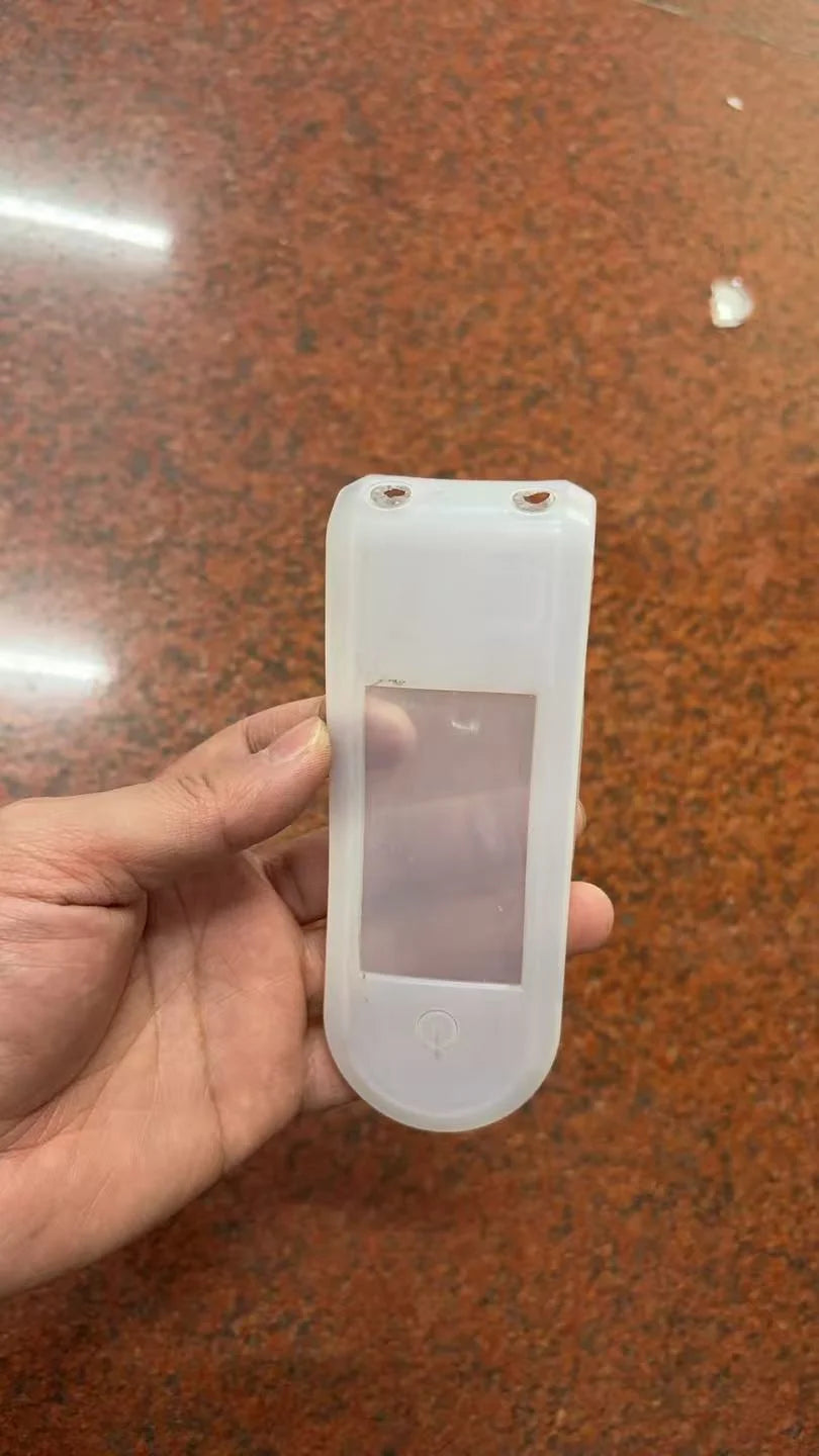 Housse de protection en silicone transparente pour compteur de trottinette électrique tenue à la main