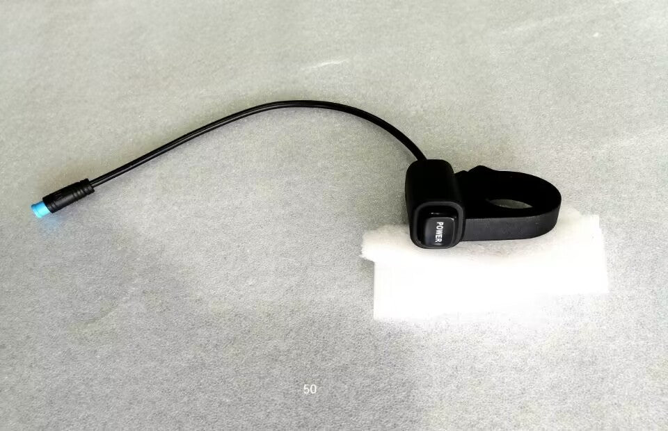 Bouton d'alimentation noir avec l'inscription POWER et son câble relié à un connecteur