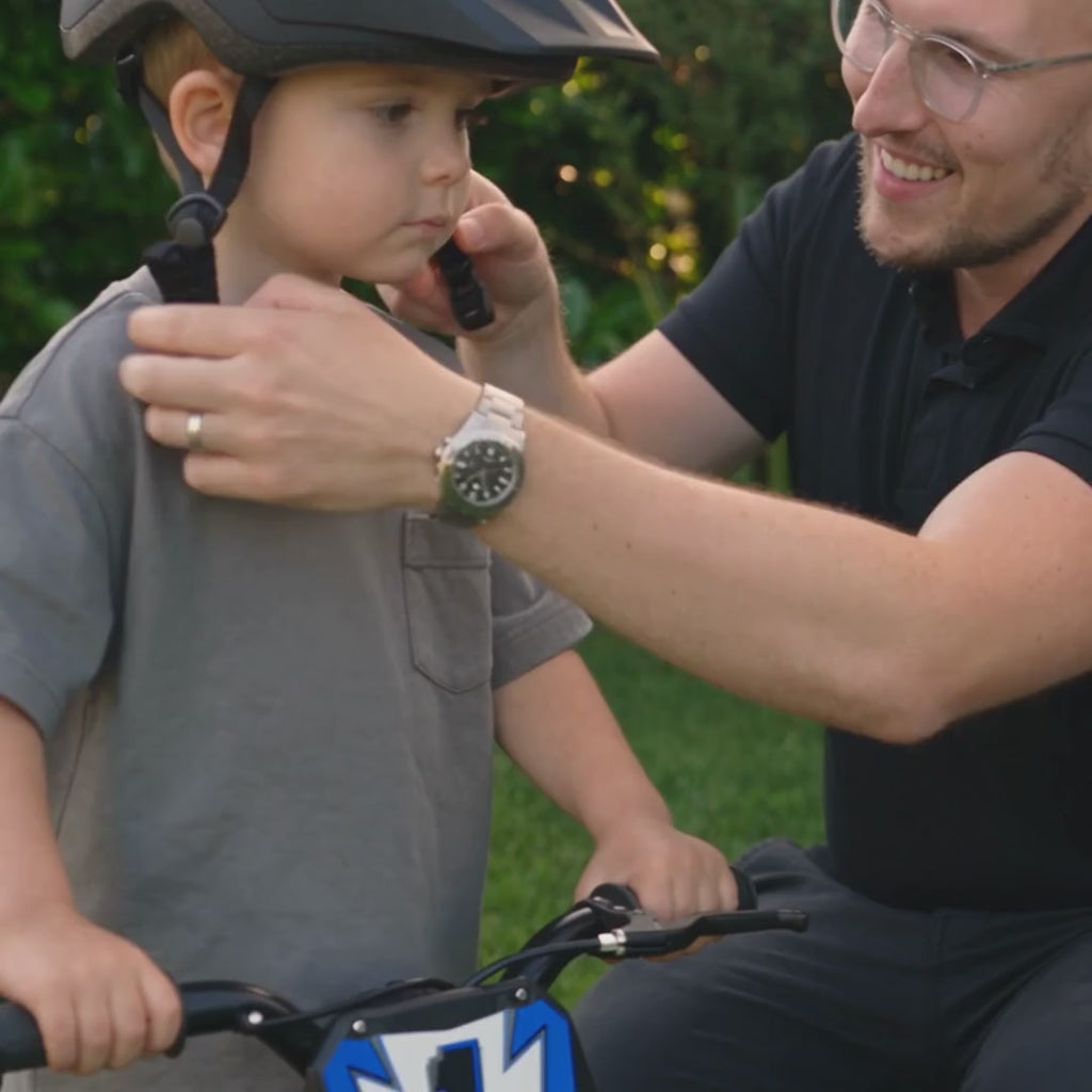 Un père règle le casque de son fils avant son premier tour de WBT Kick X