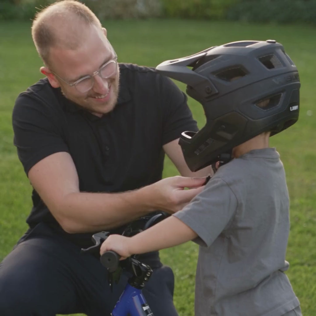 Un père règle le casque de son fils, puis l'enfant part seul sur sa draisienne WBT